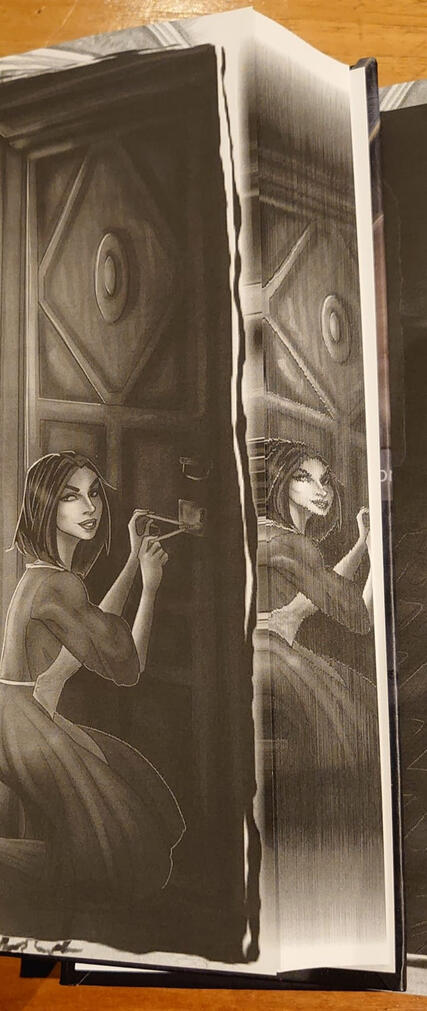 Photo showcasing internal art and the printed edge. The printed edge is the same as the art, which features a woman kneeling to lockpick a door.